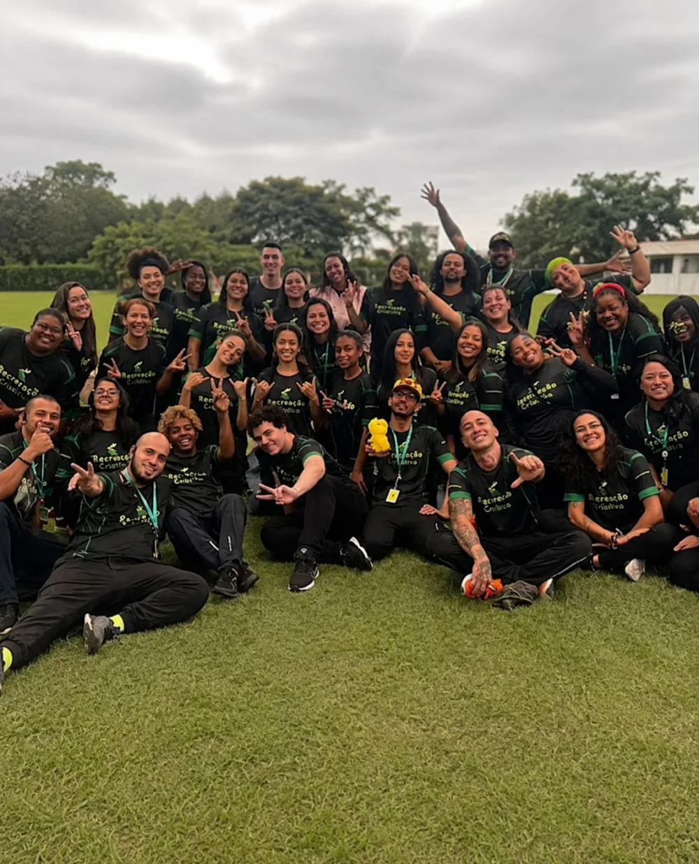 Equipe de recreadores da Recreação Criativa reunida de uniforme no gramado